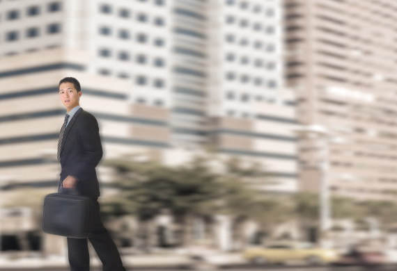 Young businessman walking in street of modern city.